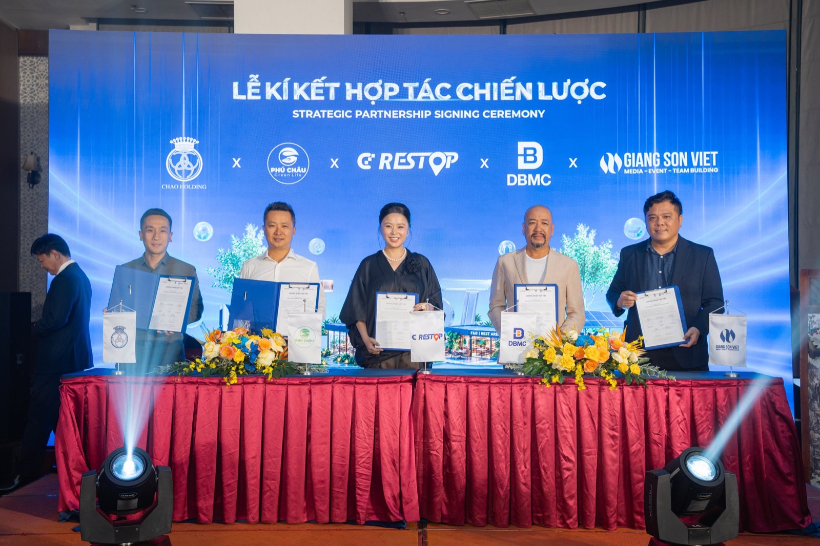 Năm đại diện đứng trước backdrop Lễ ký kết hợp tác chiến lược, giơ văn kiện vừa ký, khối logo Chao Holding, Phú Châu, CD Restop, DBMC và Giang Sơn Việt hiện phía sau